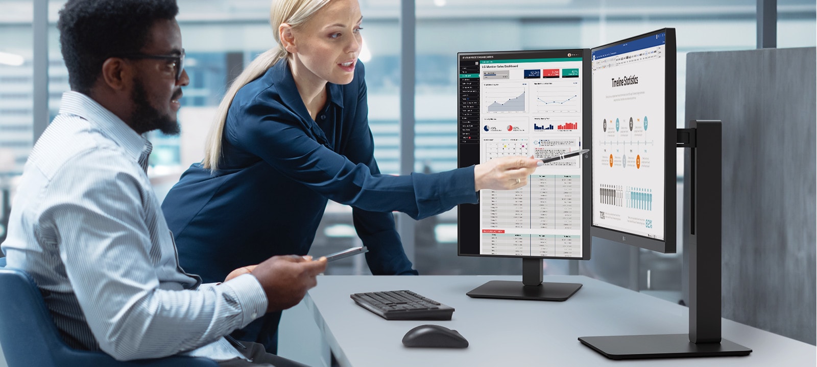 Two male and female employees discuss while looking at the monitor in the office.	