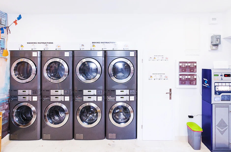 An image of LG commercial laundry machines stacked in two tiers at a laundromat.