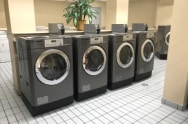 Apartment laundry room featuring LG commercial laundry front-load washing machines, neatly lined up on a clean, tiled floor.