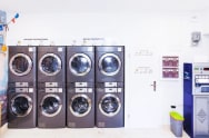An image of LG commercial laundry machines stacked in two tiers at a laundromat.