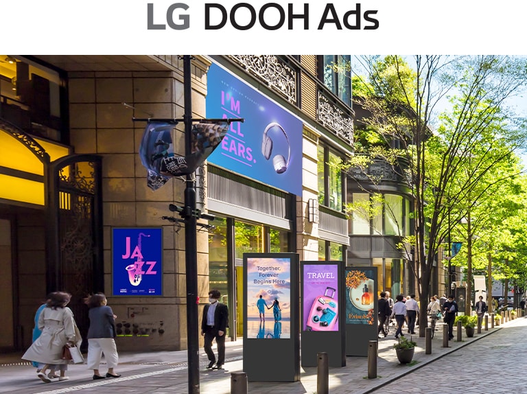 This image highlights digital signage in an outdoor space, displaying a range of ads covering topics like music, travel, and beauty.