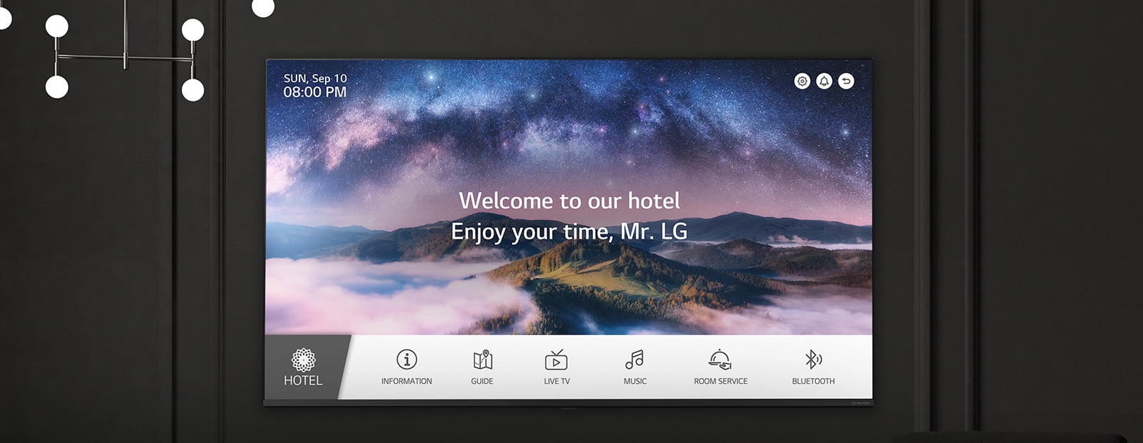 A wall in a dimly lit room features an LG TV, displaying a welcome message using the LG Pro:Centric Direct solution.