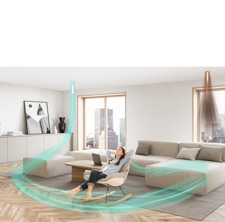 A woman sits on a chair in the living room with a couch. Twin air ducts on the ceiling cleanse the space, replacing pollution with clean blue air.