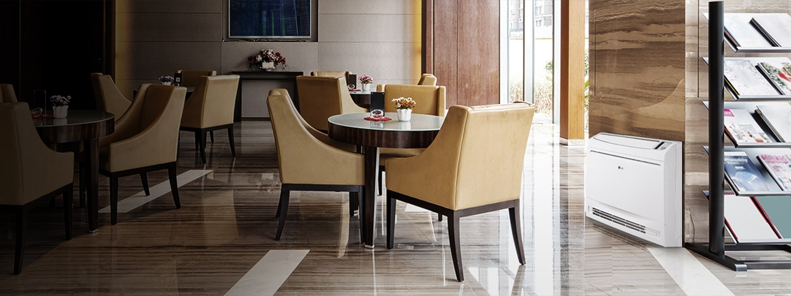 An LG Console unit nestles at the base of a pillar on the right, complementing a cafeteria-style area with a triad of caramel chairs around a table.
