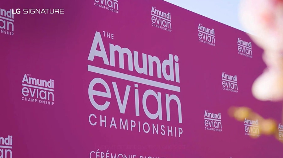 A placard with logos of The Amundi Evian Championship against a pink background.