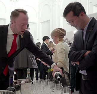 waiter is pouring drinks for a man at the lg signature artweek 2018 in russia