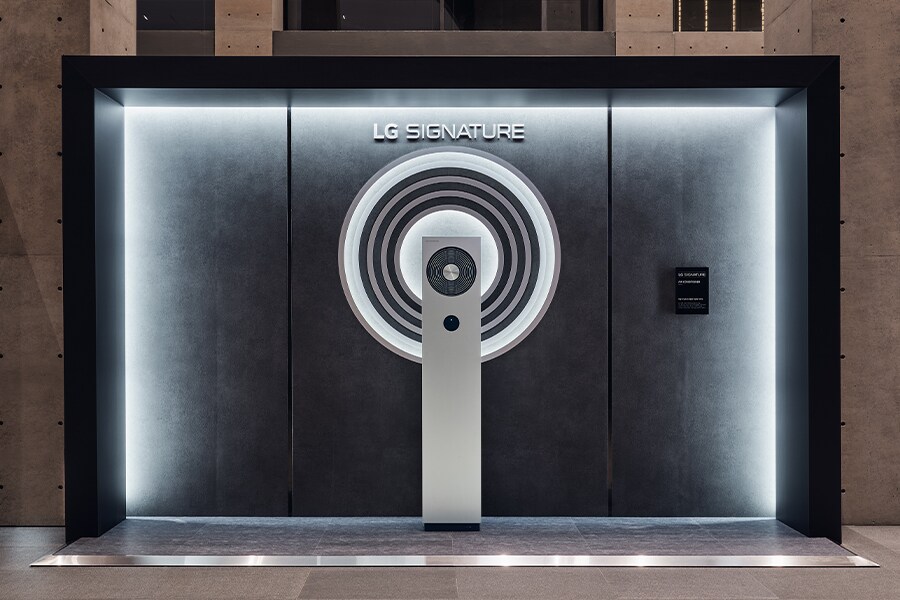 An illustration of the LG SIGNATURE Air Conditioner against a dimly lit concrete wall.