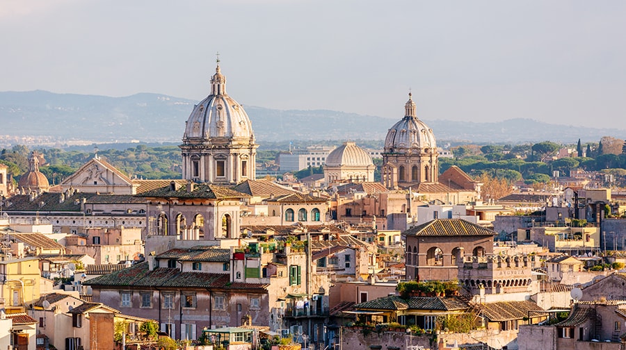 Domed roofs and terracotta-colored buildings compose the skyline of Rome.