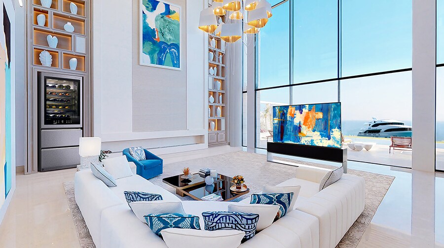 A Rollable OLED TV R in a white-and-blue themed room in front of large windows with a view of the ocean.