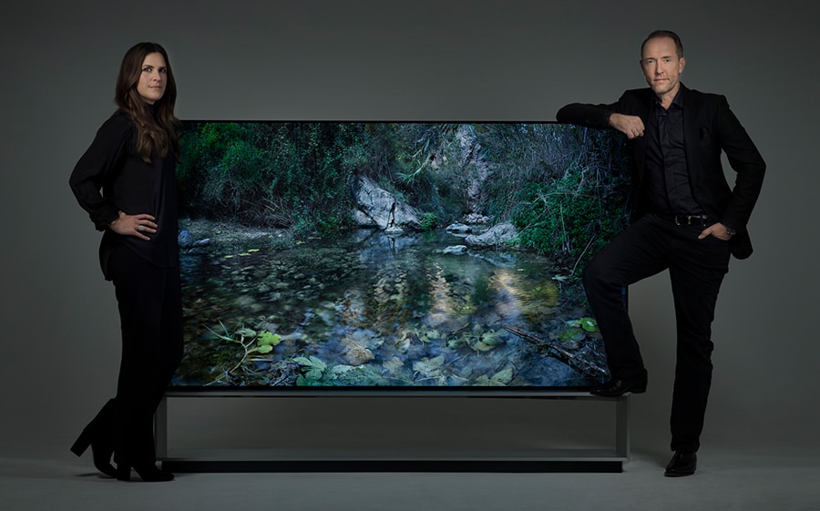 Artist duo Alexandrov Klum leaning on a LG SIGNATURE 88 TV