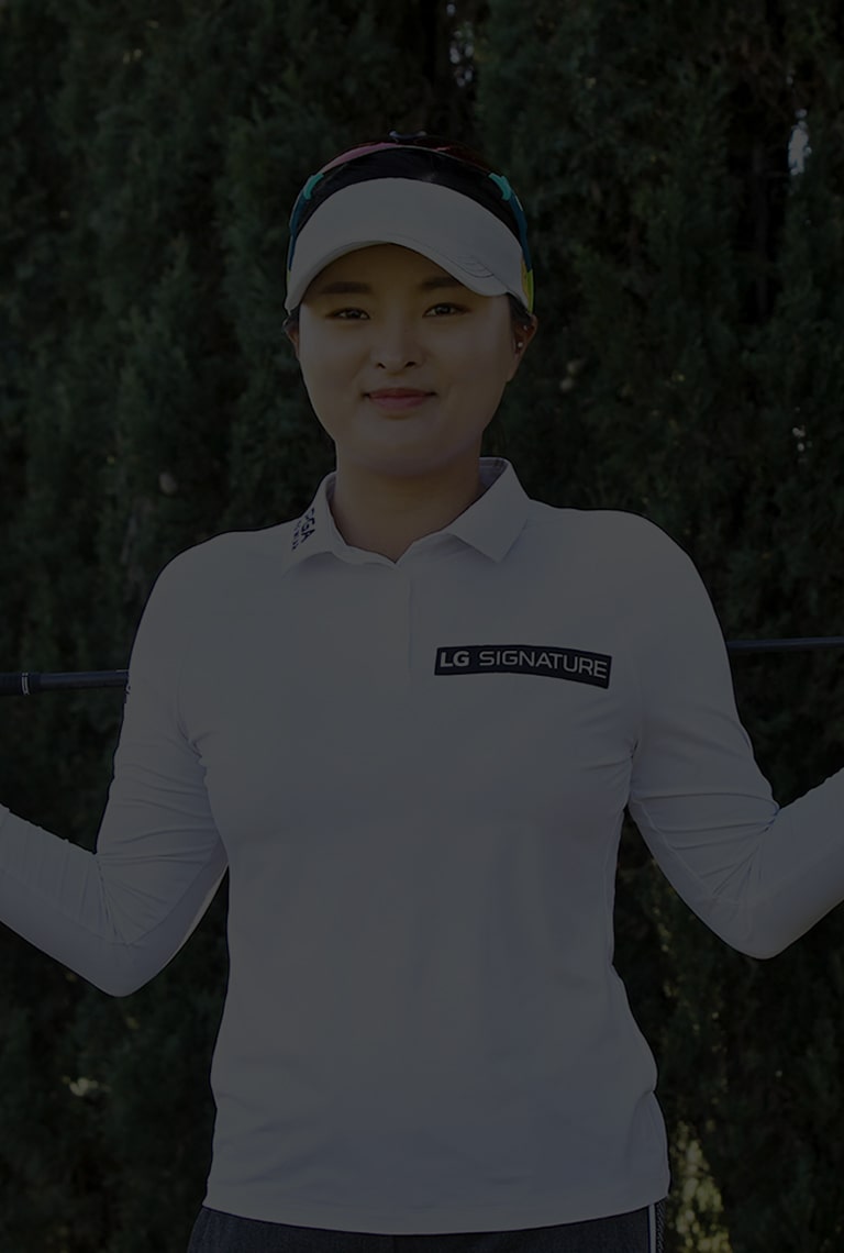 Pro golfer Ko Jin-Young is holding golf driver while smling at field.
