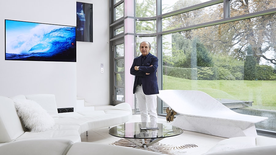 hadi teherani is standing in the living room with lg signature oled tv hung on the wall