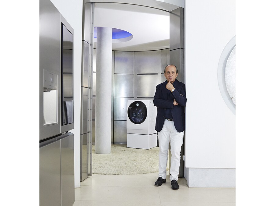 hadi teherani is leaning against the wall with lg signature refrigerator and washing machine in his house