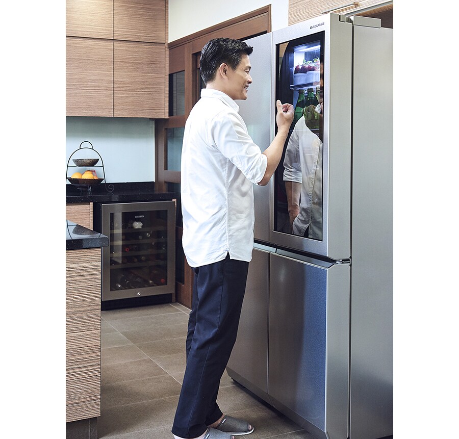 leslie tay is knocking oh the instaview of lg signature refrigerator in the kitchen
