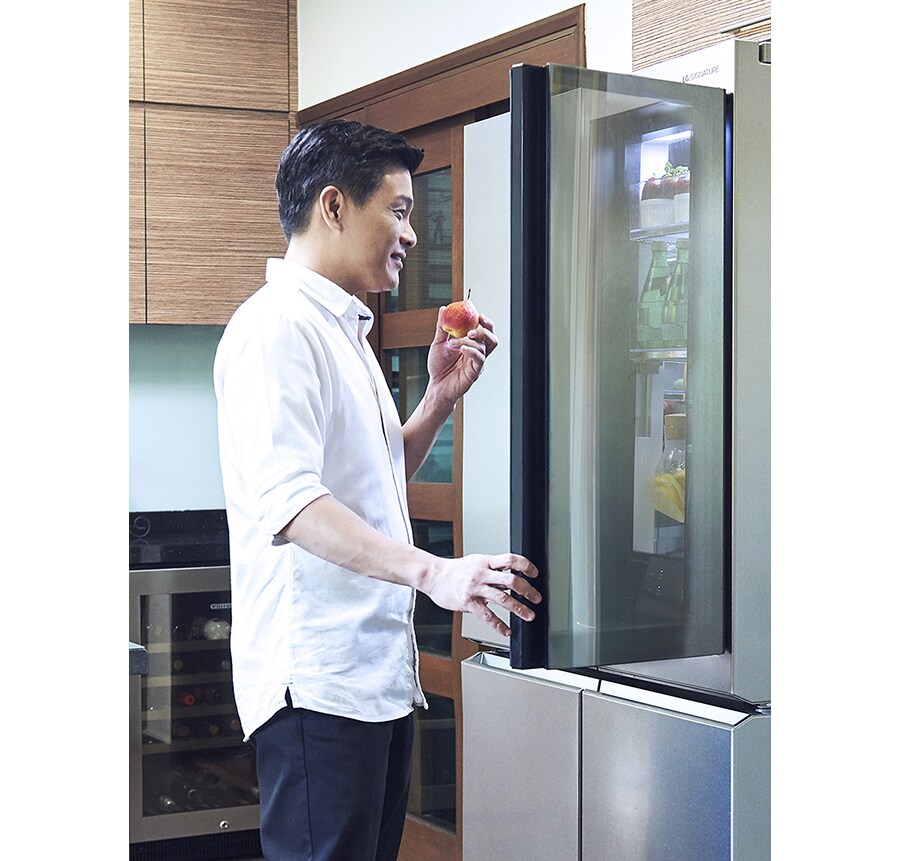 leslie tay is opening a upper door of lg signature refrigerator in the kitchen