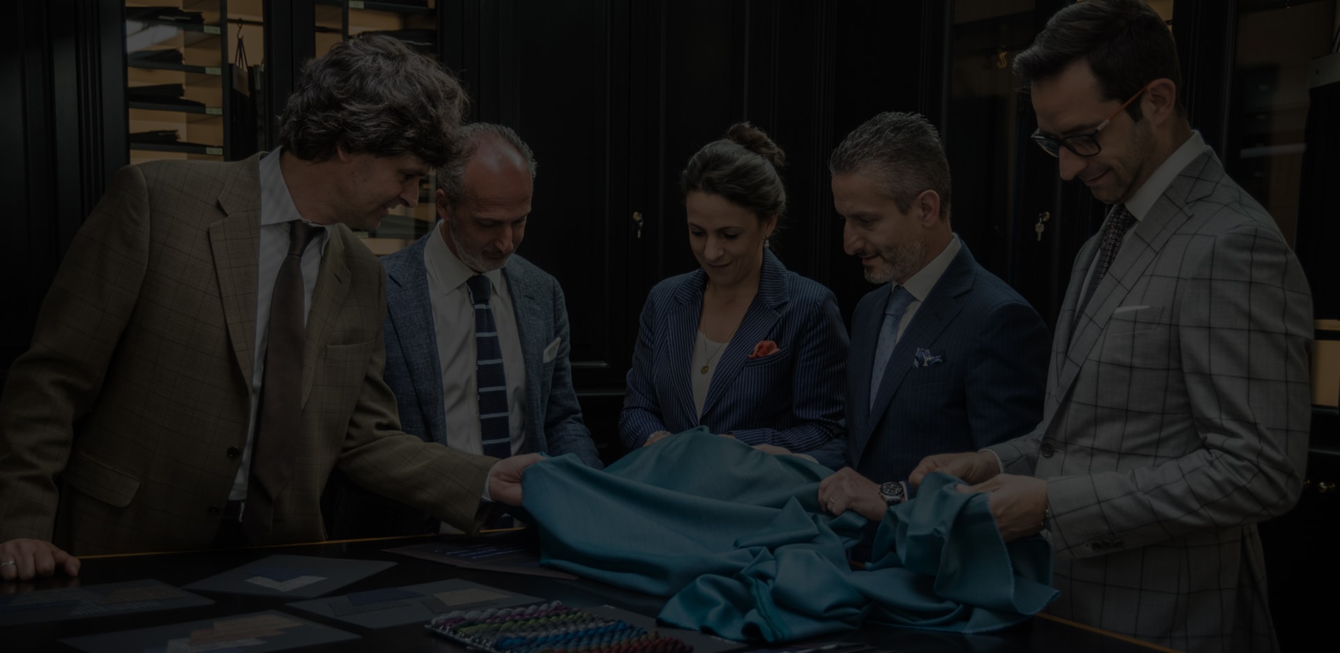 A group of people examine fabric.