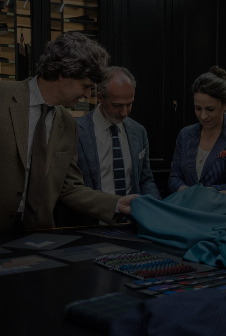 A group of people examine fabric.