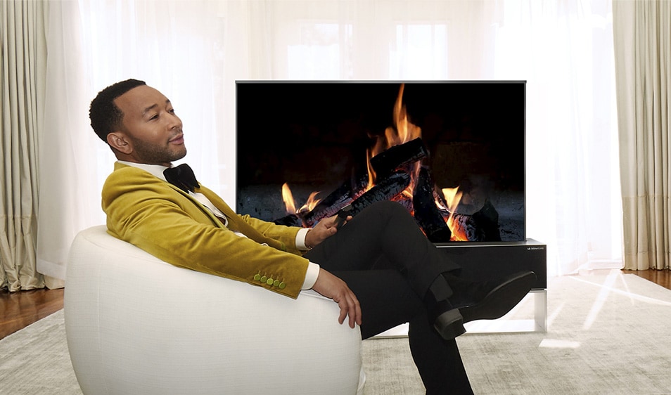John Legend relaxing in front of a rollable TV