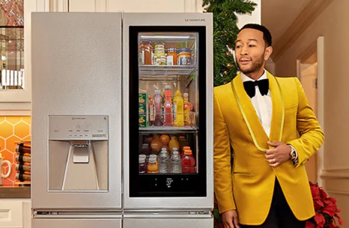 Singer John Legend leaning on an LG SIGNATURE Refrigerator.