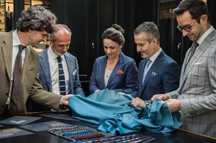 A group of people examine fabric.