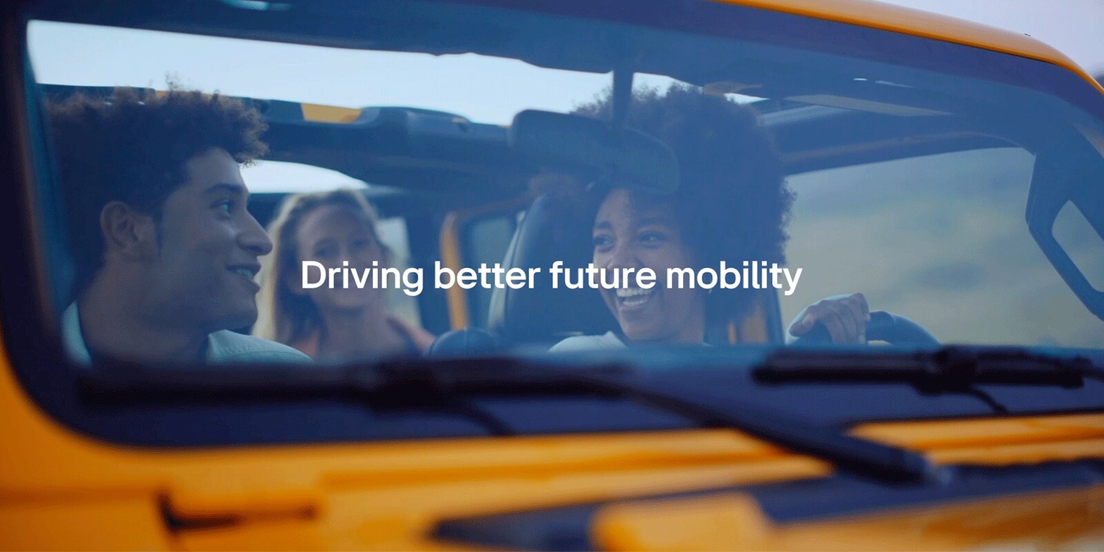 An image of a woman smiling happily while driving with her friends, with the words "Driving better future mobility" above it.