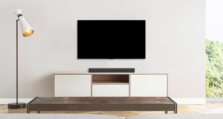 Μια τηλεόραση και ένα soundbar τοποθετημένα σε ένα λιτό σαλόνι.