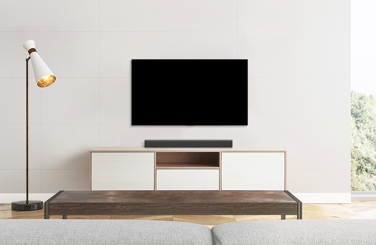 Μια τηλεόραση και ένα soundbar τοποθετημένα σε ένα λιτό σαλόνι.