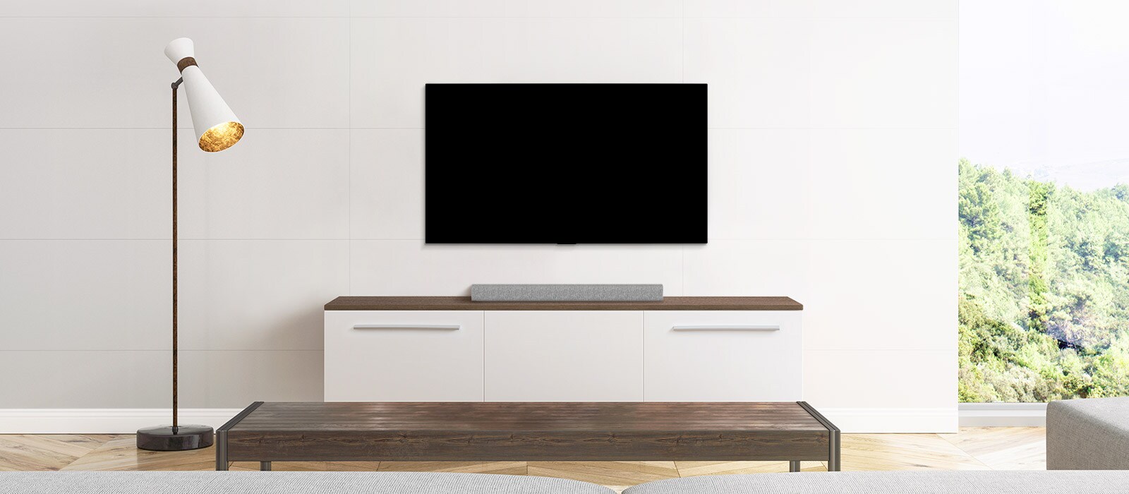 Μια τηλεόραση και ένα soundbar τοποθετημένα σε ένα λιτό σαλόνι.