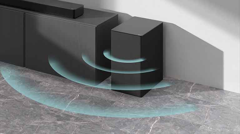 Ένα sound bar είναι τοποθετημένο πάνω στο ερμάριο. Δίπλα, ένα ασύρματο υπογούφερ είναι τοποθετημένο στο δάπεδο. Μπλε γραφικά ήχου προέρχονται από το υπογούφερ.