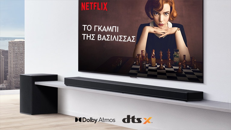 Η τηλεόραση είναι τοποθετημένη στον τοίχο. Στην οθόνη της τηλεόρασης φαίνεται η αφίσα μιας τηλεοπτικής σειράς. Το LG Soundbar βρίσκεται ακριβώς κάτω από την τηλεόραση σε ένα λευκό ράφι, με ένα subwoofer ακριβώς δίπλα. Στο κάτω ενδιάμεσο μέρος της εικόνας φαίνονται τα λογότυπα Dolby Atmos και DTS:X.