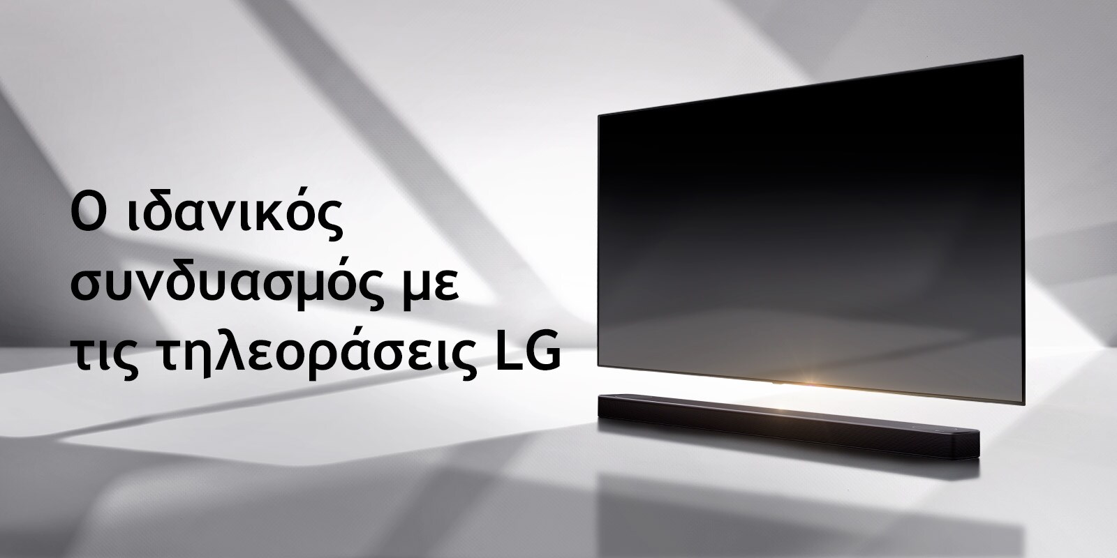 Ένα soundbar και μια τηλεόραση τοποθετημένα σε ένα λευκό δάπεδο, με μια σκιά που έρχεται από έξω ακριβώς από πίσω τους.