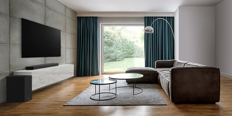 Μια τηλεόραση, ένα soundbar και ένα subwoofer σε ένα μεγάλο σαλόνι. Ένα κύμα με πλέγμα βγαίνει από το soundbar, μετρώντας ολόκληρο τον χώρο του σαλονιού. 