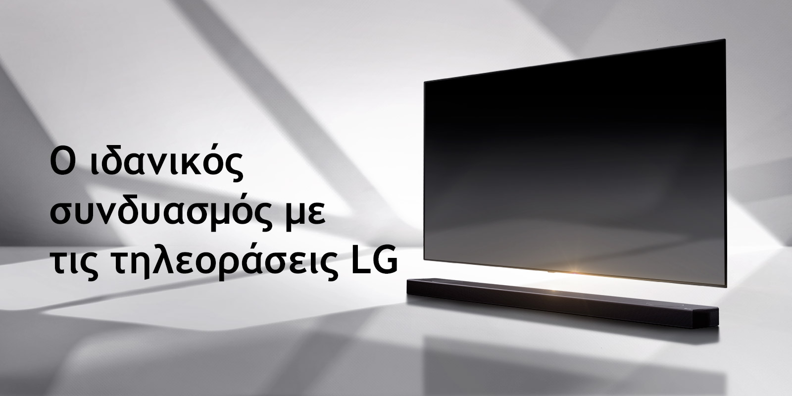 Ένα soundbar και μια τηλεόραση τοποθετημένα σε ένα λευκό δάπεδο, με μια σκιά που έρχεται από έξω ακριβώς από πίσω τους.