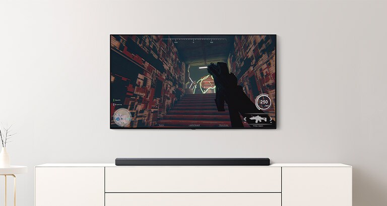 Υπάρχει μια τηλεόραση και ένα soundbar σε ένα σαλόνι. Στην οθόνη μιας τηλεόρασης προβάλλεται ένα παιχνίδι FPS και το κανάλι αλλάζει σε έναν ποδοσφαιρικό αγώνα. (αναπαραγωγή βίντεο)