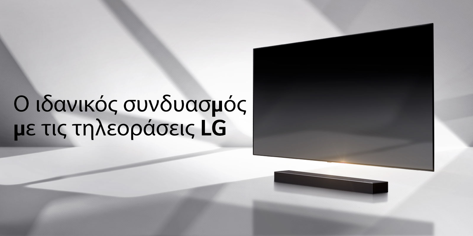 Ένα soundbar και μια τηλεόραση τοποθετημένα σε ένα λευκό δάπεδο, με μια σκιά που έρχεται από έξω ακριβώς από πίσω τους.