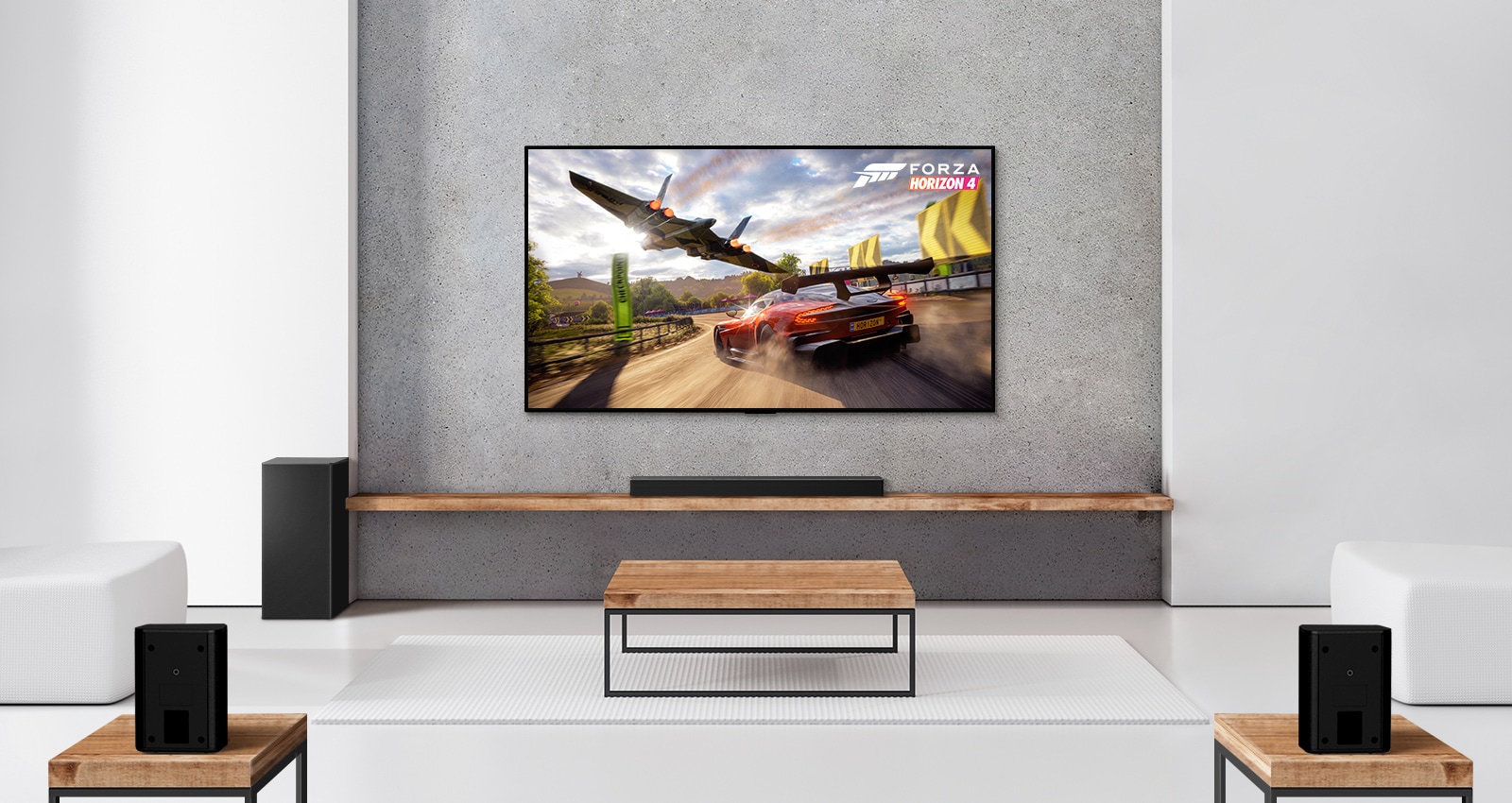 Ένα σετ με 2 πίσω ηχεία, ένα subwoofer και ένα soundbar και μια τηλεόραση σε ένα σαλόνι με λευκή απόχρωση. Στην οθόνη της τηλεόρασης φαίνεται ένα αυτοκίνητο που τρέχει και ένα διαστημόπλοιο.