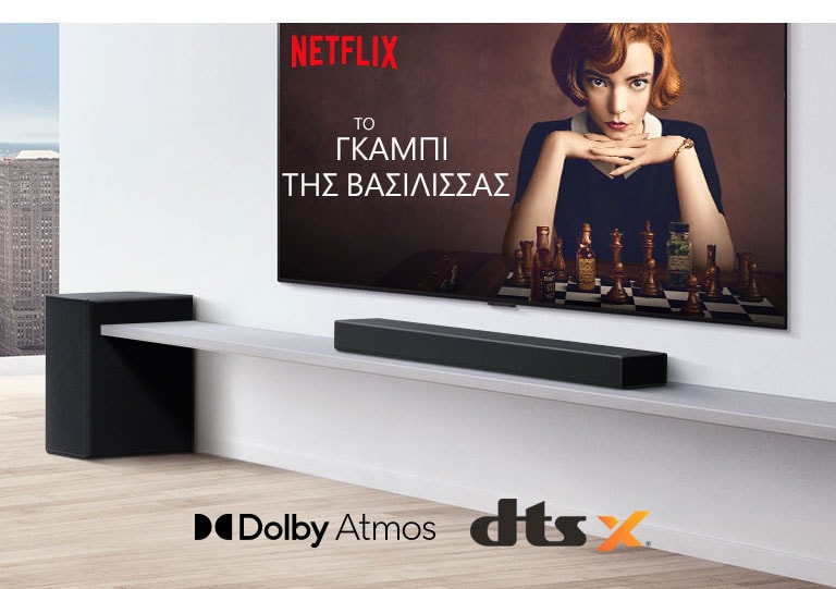 Η τηλεόραση είναι τοποθετημένη στον τοίχο. Στην οθόνη της τηλεόρασης φαίνεται η αφίσα μιας τηλεοπτικής σειράς. Το LG Soundbar βρίσκεται ακριβώς κάτω από την τηλεόραση σε ένα λευκό ράφι, με ένα subwoofer ακριβώς δίπλα. Στο κάτω ενδιάμεσο μέρος της εικόνας φαίνονται τα λογότυπα Dolby Atmos και DTS:X.