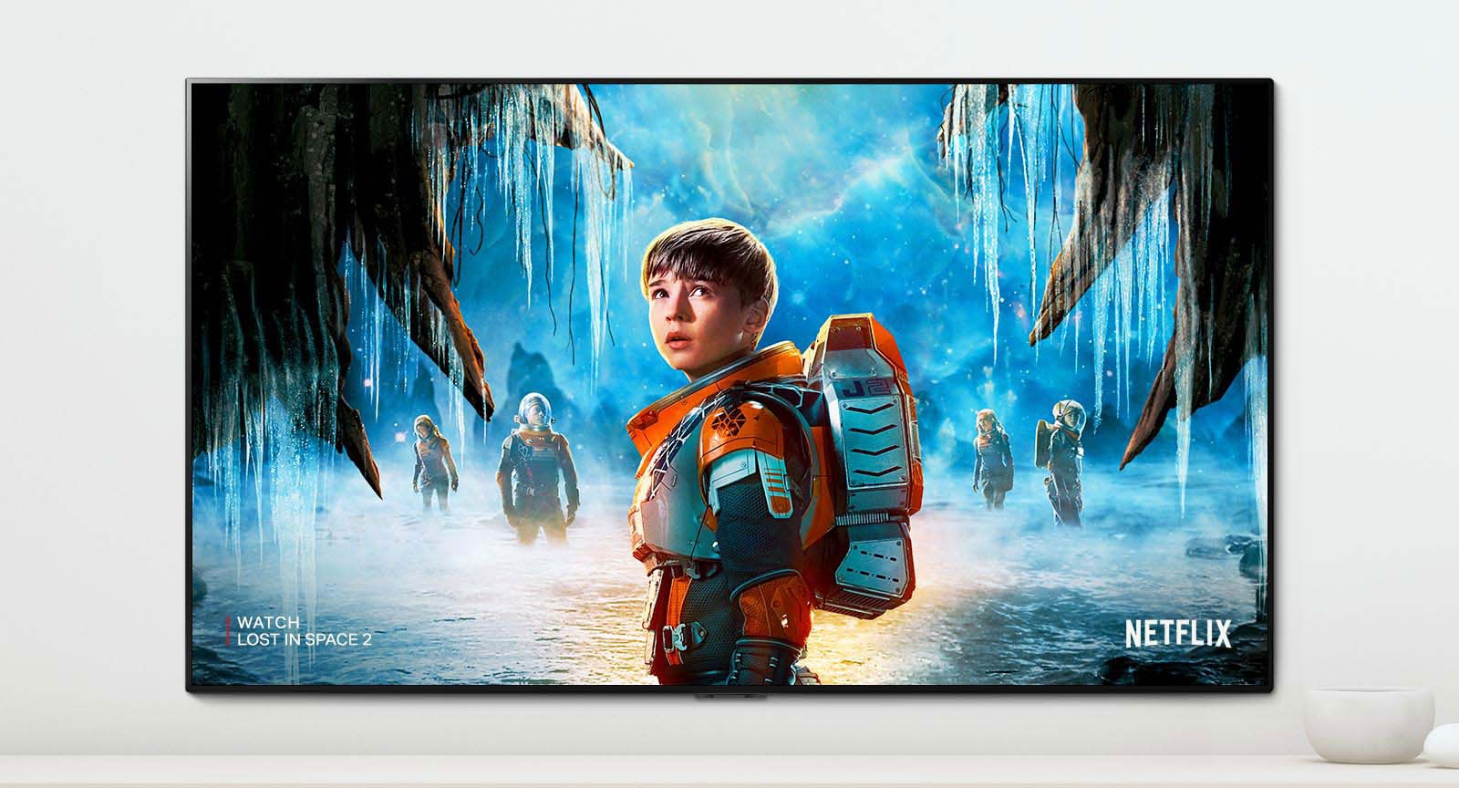 Σκηνή από τη σειρά "Lost in Space 2", όπου στην οθόνη της τηλεόρασης απεικονίζονται οι πρωταγωνιστές