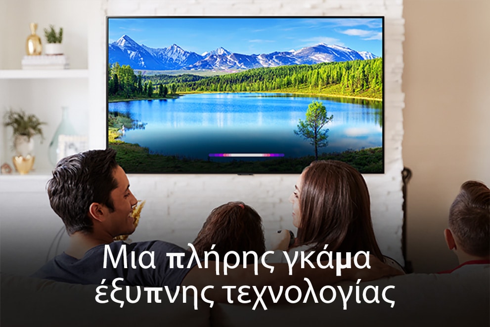 Μια οικογένεια σε ένα φωτεινό σαλόνι που βλέπει ένα τοπίο σε μια επιτοίχια τηλεόραση.