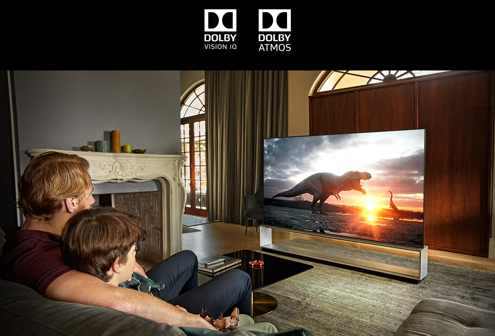 Το σήμα του DOLBY VISION IQ / Το σήμα του DOLBY ATMOS，Πατέρας και γιος βλέποντας ένα ντοκιμαντέρ για δεινόσαυρους σε μια τηλεόραση με μεγάλη οθόνη