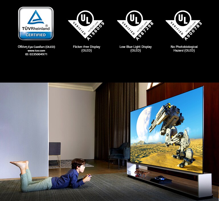 Ένα αγόρι μπρούμυτα στο χαλί, παρακολουθεί κινούμενα σχέδια σε μια τηλεόραση χωρίς μπλε φωτισμό, Το σήμα του TÜV Rheinland / Το σήμα του UL Verification 