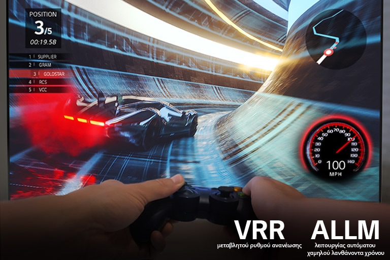 Στην οθόνη φαίνεται η ομαλή κίνηση σε ένα παιχνίδι αγώνων ταχύτητας σε υψηλή ανάλυση, με δύο χέρια που κρατούν ένα χειριστήριο