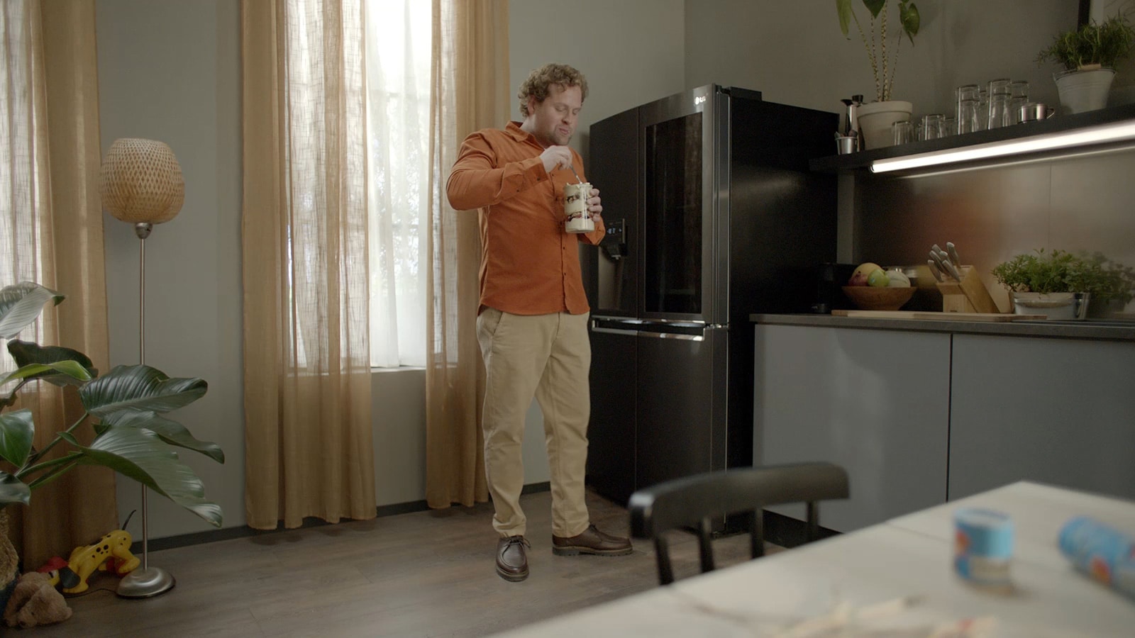 Ένας άντρας στέκεται δίπλα στο ψυγείο καθώς τρώει ένα κομμάτι τούρτα. Αυτή η εικόνα διαδέχεται την άλλη εικόνα. Όταν ένας άντρας χτυπά την πόρτα του ψυγείου, μπορούμε να δούμε τι υπάρχει μέσα.