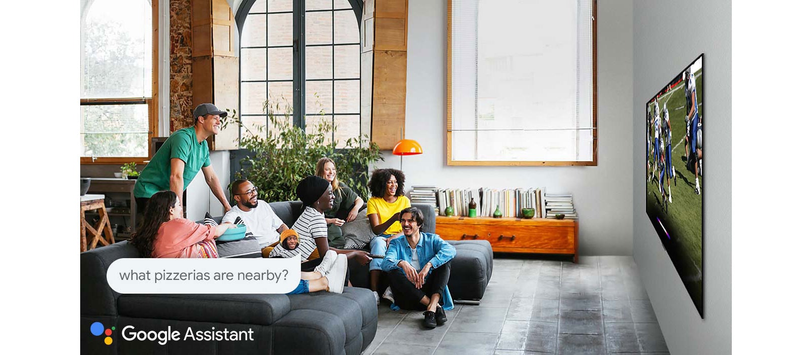 Μια γυναίκα που παρακολουθεί ποδόσφαιρο στην τηλεόραση με φίλους και ρωτά το Google Assistant ποιες πιτσαρίες υπάρχουν κοντά στο σπίτι της