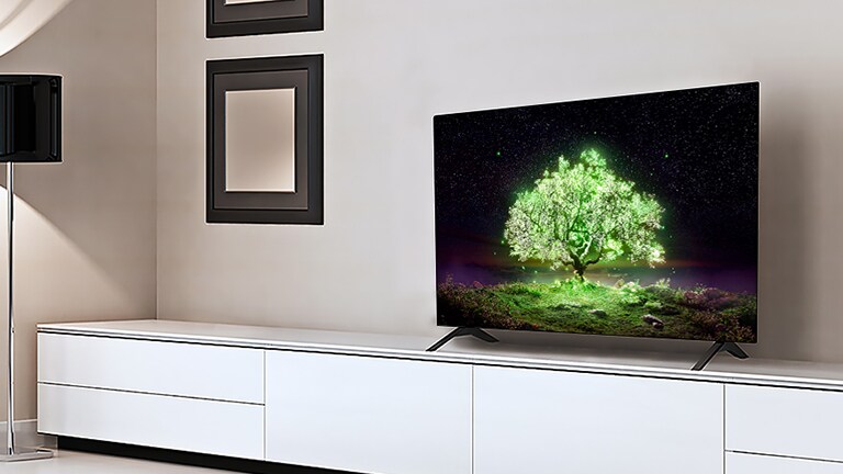 Μια τηλεόραση σε ένα καθιστικό, που δείχνει ένα λαμπερό πράσινο δέντρο.
