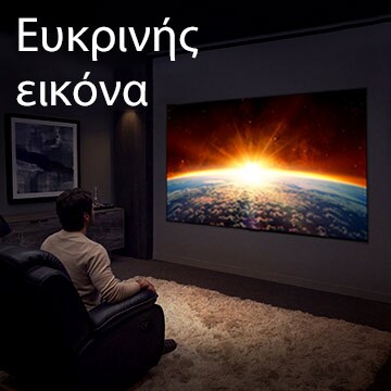 Ένας άντρας καθισμένος σε έναν καναπέ σε ένα σκοτεινό δωμάτιο, ο οποίος παρακολουθεί τηλεόραση, η οποία δείχνει τον ήλιο που ανατέλλει πίσω από τη γη.