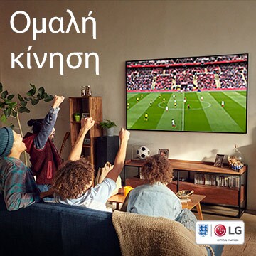 Τέσσερα άτομα καθισμένα στον καναπέ ενός σαλονιού, παρακολουθώντας έναν ποδοσφαιρικό αγώνα.