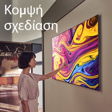 Μια γυναίκα κοιτάζει μια τηλεόραση αναρτημένη στον τοίχο, στην οθόνη της οποίας φαίνεται ένα έργο τέχνης.