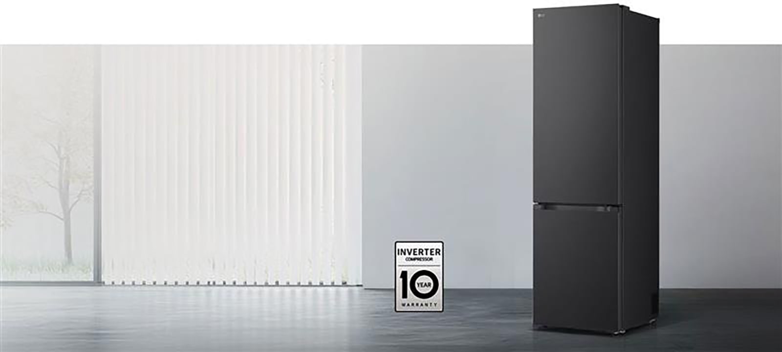 LG ψυγείο bottom freezer μπροστινή όψη σε φωτεινό χώρο με κάθετες περσίδες, με εικονίδια για 10ετή εγγύηση στον συμπιεστή και Ενεργειακή Απόδοση Α από κάτω.