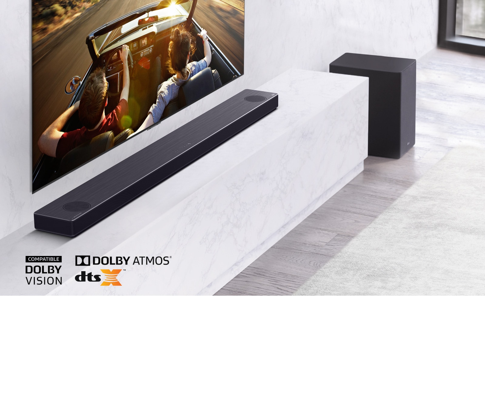 TV στον τοίχο και το LG SoundBar κάτω σε ένα ράφι, με ένα Subwoofer στα δεξιά. Στην TV - ένα ζευγάρι μέσα σε ένα αυτοκίνητο.